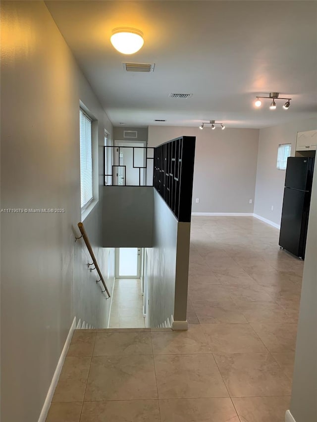 corridor featuring light tile patterned floors and a wealth of natural light