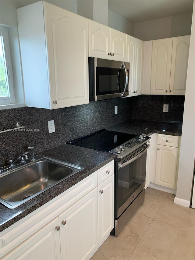 kitchen with backsplash, stainless steel appliances, and white cabinetry