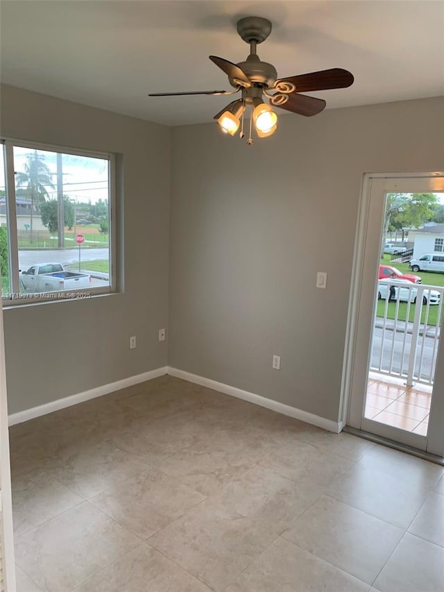 tiled empty room featuring ceiling fan