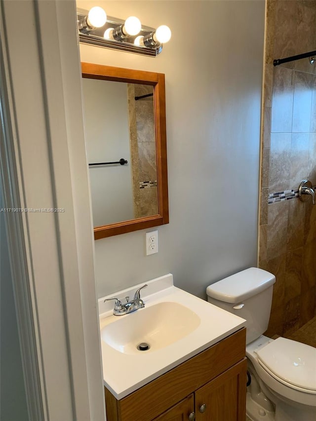 bathroom featuring vanity, toilet, and walk in shower