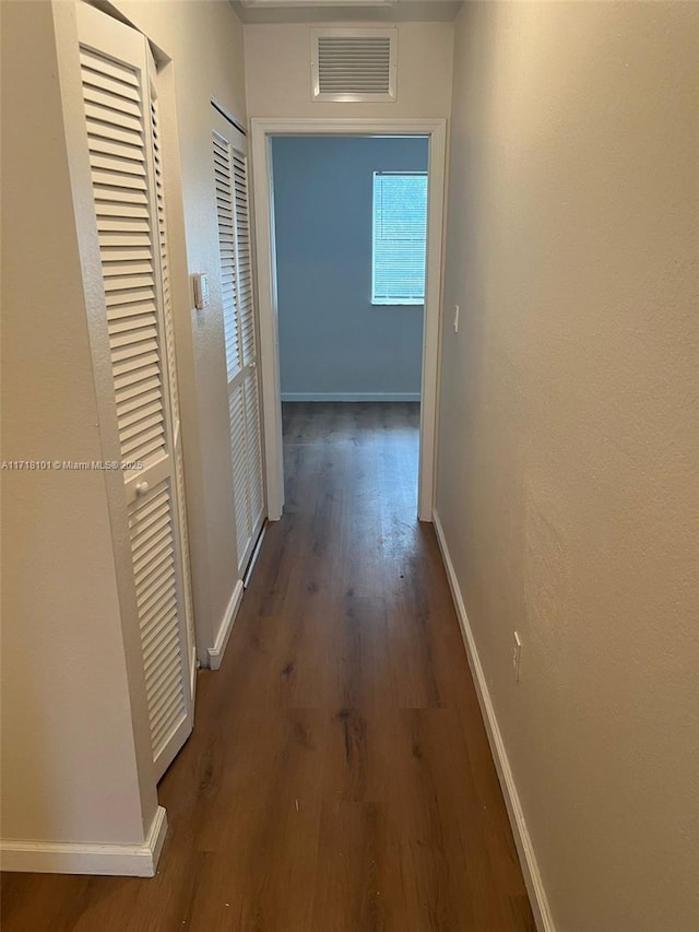 corridor with dark hardwood / wood-style flooring