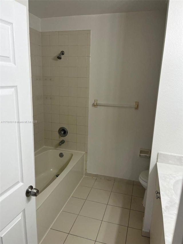 full bathroom featuring tile patterned flooring, vanity, tiled shower / bath combo, and toilet