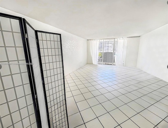 unfurnished room with floor to ceiling windows and light tile patterned flooring