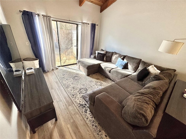 living room with lofted ceiling with beams, wood ceiling, and light wood-type flooring