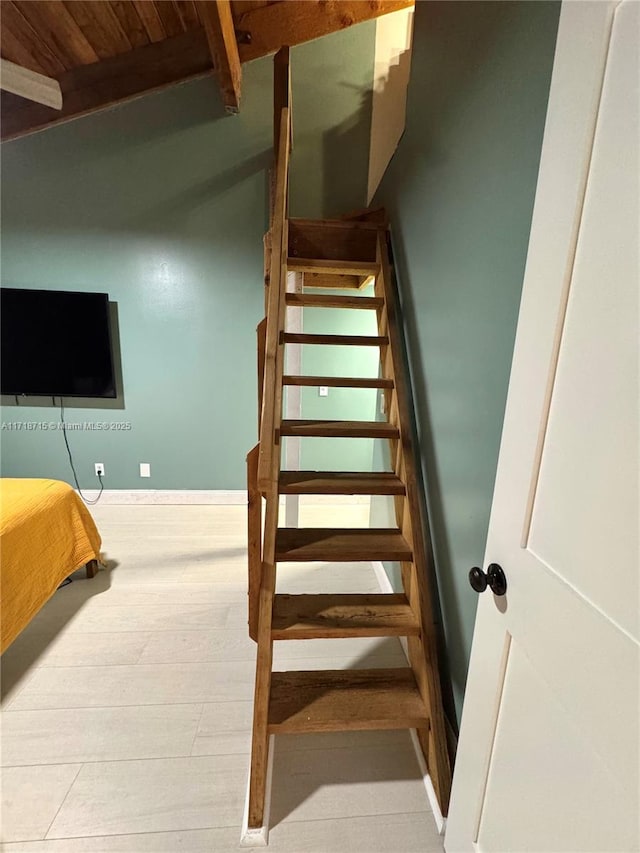 stairway with wooden ceiling and beamed ceiling