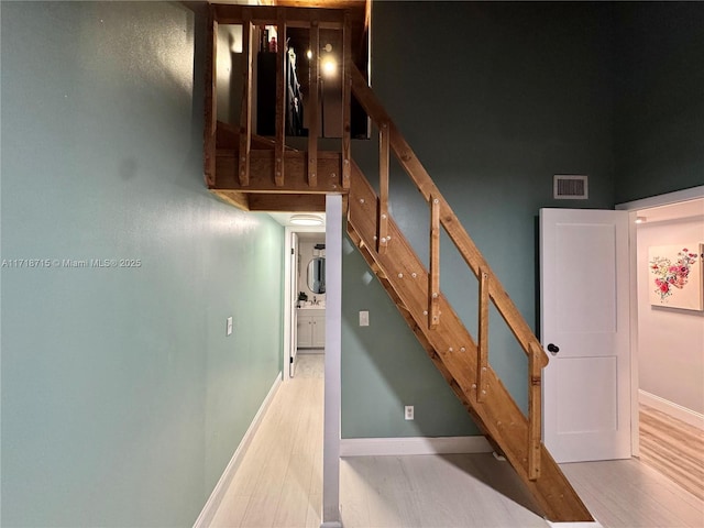 staircase featuring a high ceiling and wood-type flooring