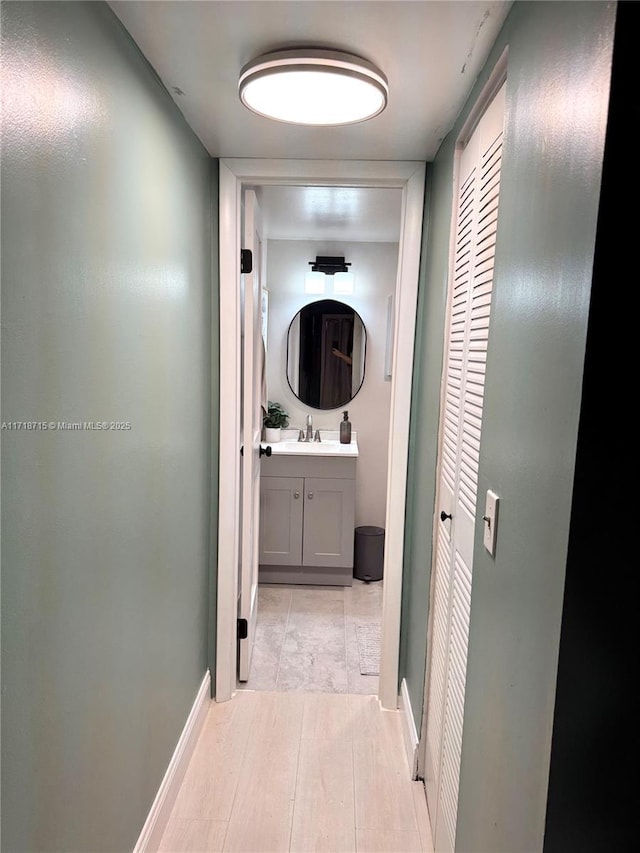 hallway with light hardwood / wood-style floors and sink