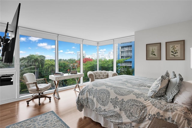 bedroom with wood-type flooring and floor to ceiling windows