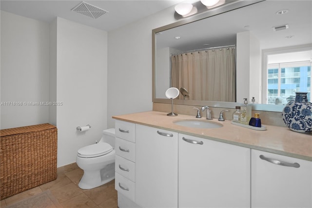 bathroom featuring tile patterned flooring, vanity, and toilet