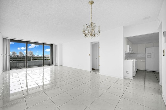 interior space featuring a textured ceiling, an inviting chandelier, a wall of windows, and light tile patterned flooring