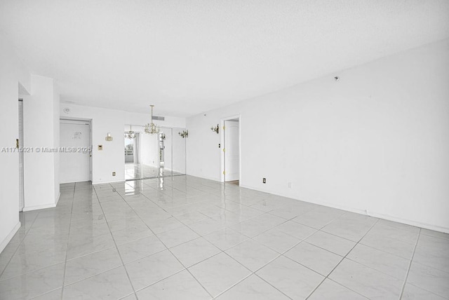 unfurnished room with a chandelier