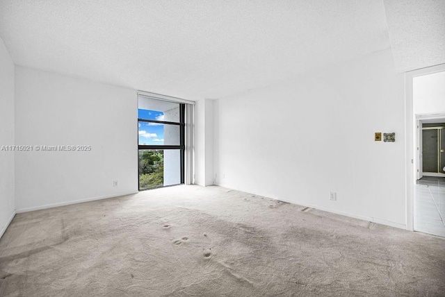 carpeted empty room featuring a textured ceiling