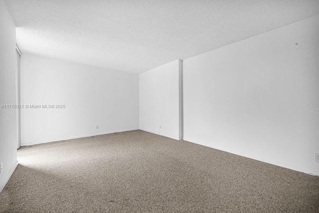 carpeted spare room with a textured ceiling