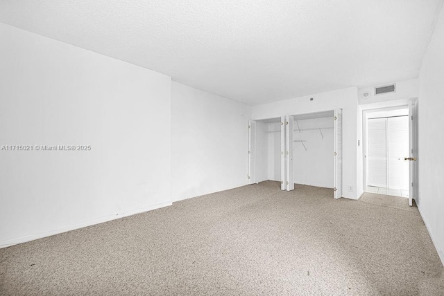 unfurnished bedroom with a textured ceiling and carpet floors