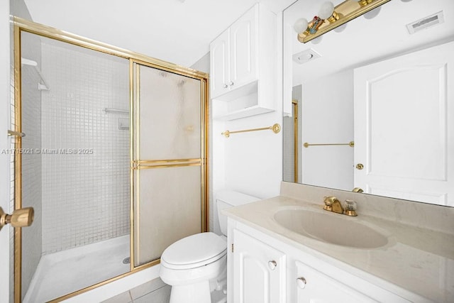 bathroom with tile patterned floors, a shower with door, vanity, and toilet