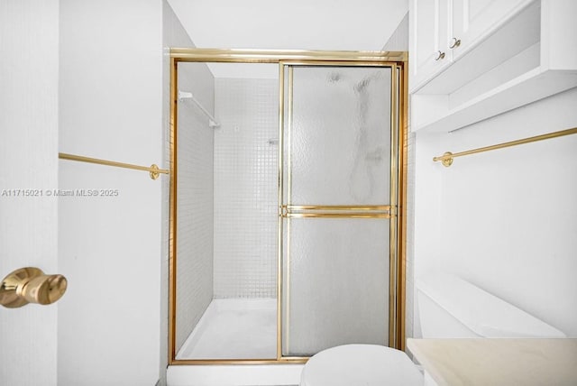 bathroom with a shower with shower door and toilet