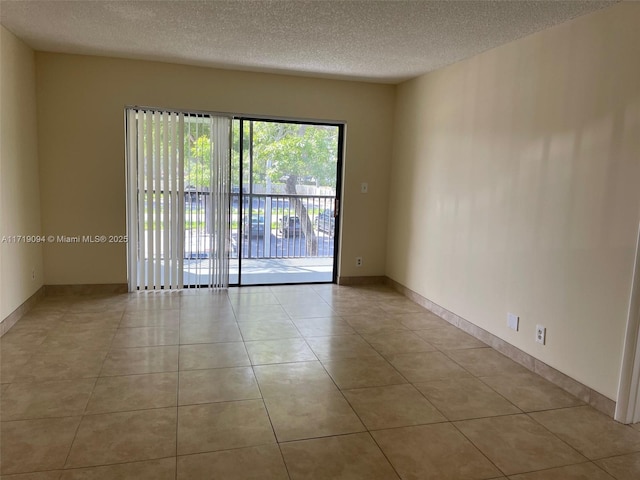 tiled empty room with a textured ceiling