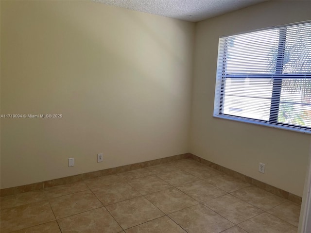 tiled spare room with a textured ceiling