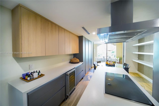 kitchen featuring light brown cabinetry, light hardwood / wood-style flooring, wine cooler, and range hood