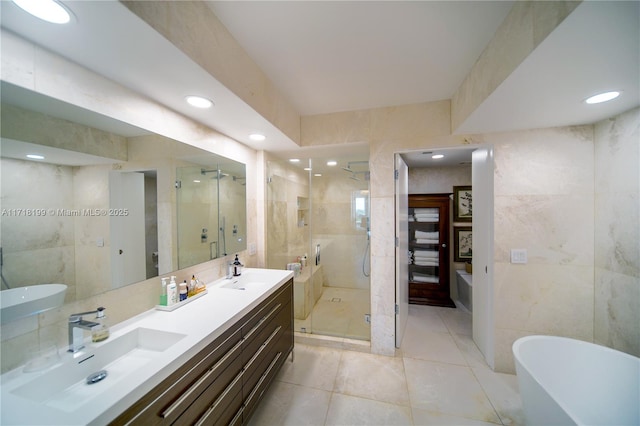 bathroom featuring tile patterned flooring, vanity, separate shower and tub, and tile walls