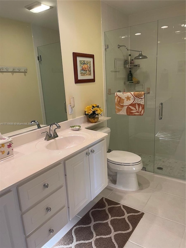 bathroom featuring tile patterned flooring, vanity, toilet, and walk in shower