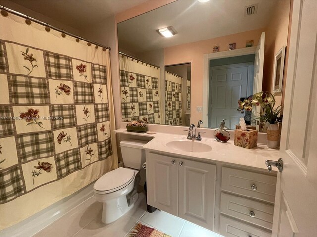 bathroom with tile patterned flooring, vanity, curtained shower, and toilet