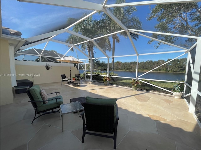 view of patio / terrace with a water view and a lanai