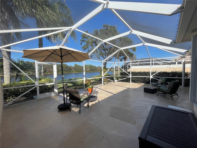 view of patio featuring outdoor lounge area, glass enclosure, and a water view