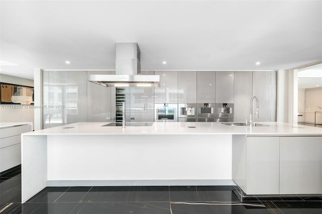 kitchen featuring black electric stovetop, extractor fan, a spacious island, sink, and white cabinetry