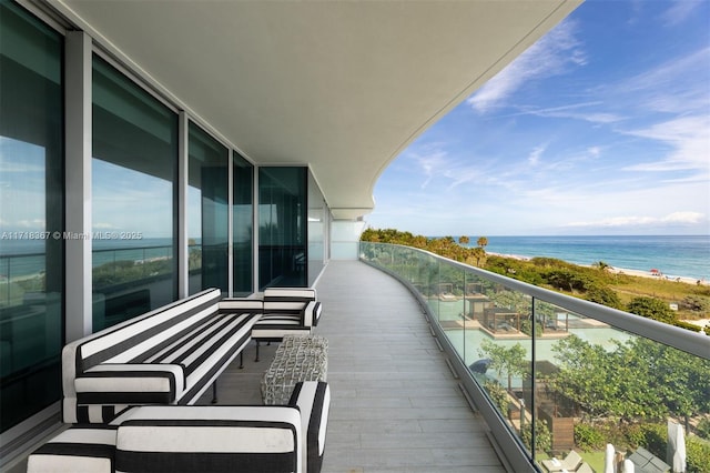 balcony featuring a view of the beach and a water view