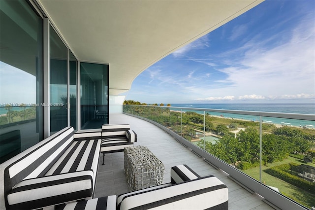 balcony featuring a view of the beach and a water view