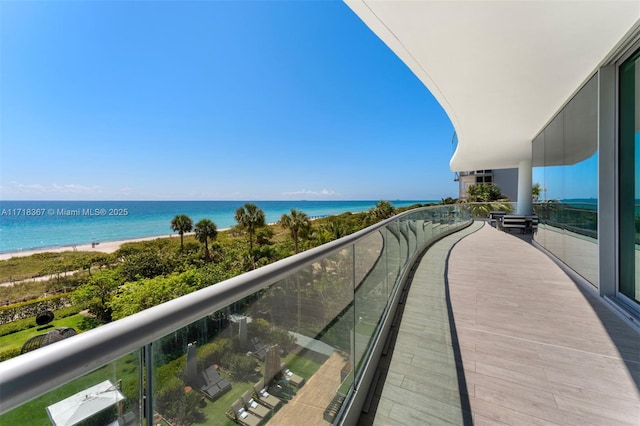 balcony with a water view and a beach view