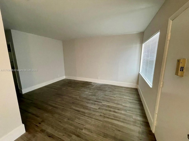 spare room featuring dark wood-type flooring