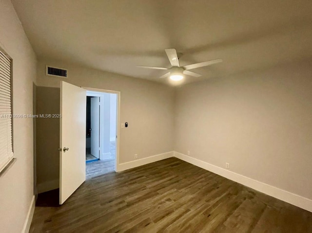 spare room with ceiling fan and dark wood-type flooring