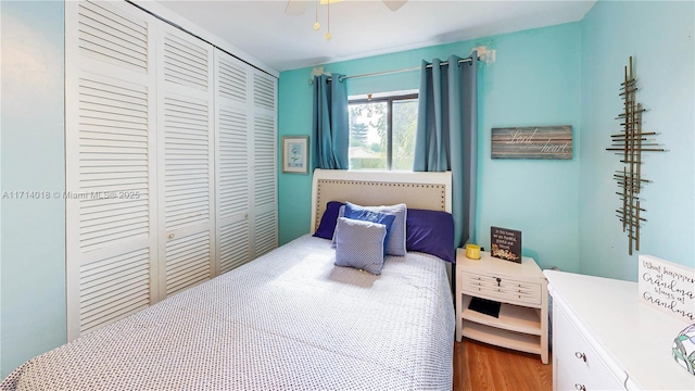 bedroom with ceiling fan, a closet, and wood-type flooring