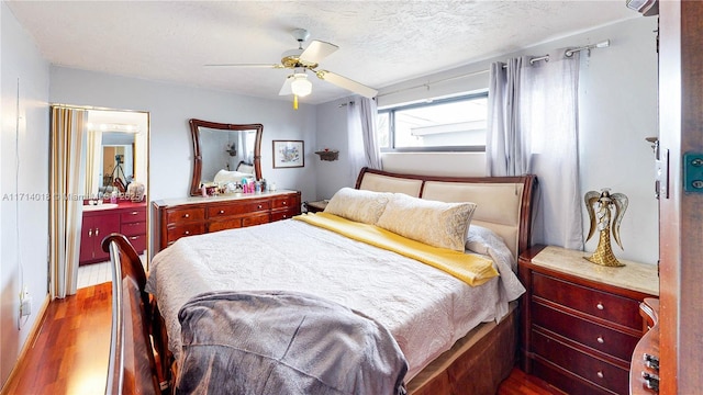 bedroom featuring a textured ceiling, ceiling fan, and hardwood / wood-style flooring