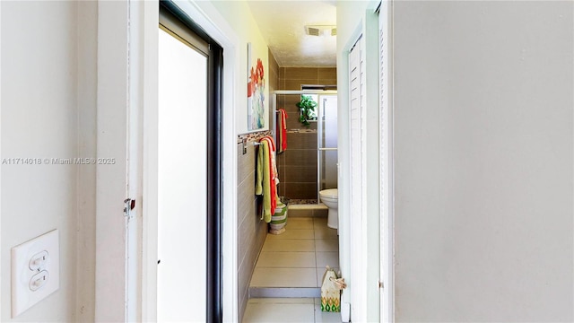 hall with tile walls and tile patterned floors