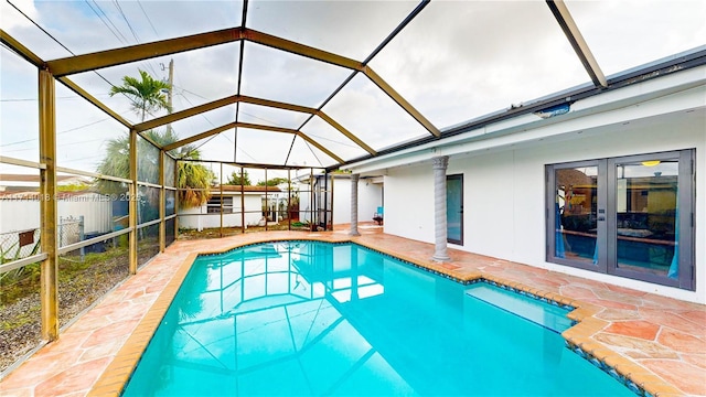 view of pool with glass enclosure, a patio area, and french doors