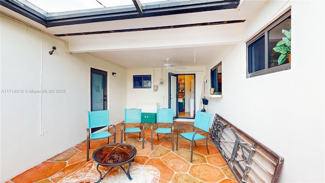 exterior space with ceiling fan and an outdoor fire pit