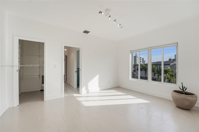 unfurnished bedroom with light tile patterned floors, a spacious closet, and a closet