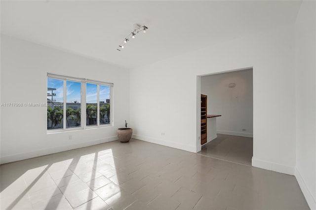 spare room featuring light tile patterned flooring and rail lighting