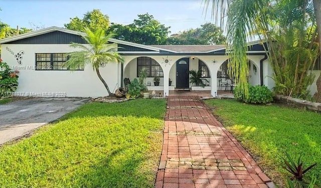 ranch-style home featuring a porch and a front yard