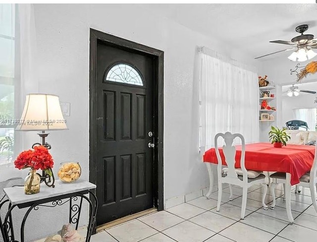 foyer entrance with ceiling fan and light tile patterned floors