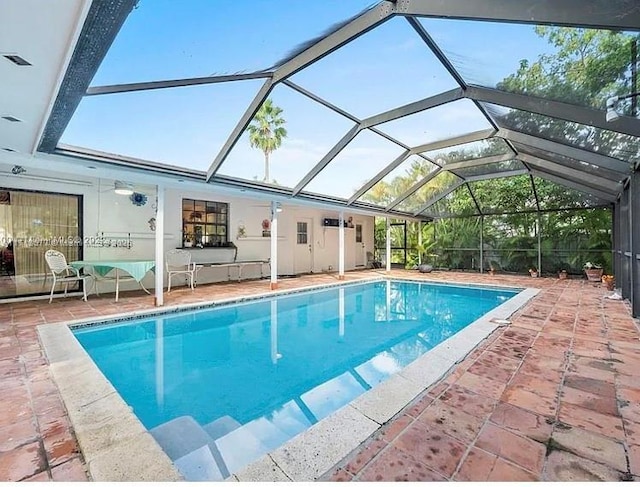 view of swimming pool featuring a lanai and a patio area