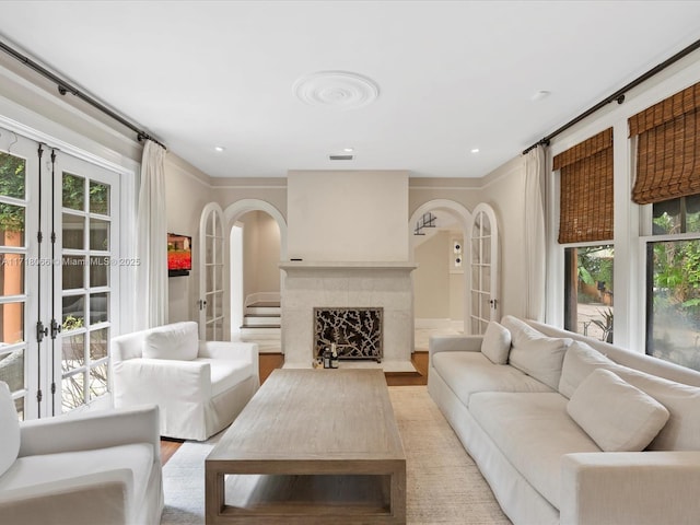 living room featuring light hardwood / wood-style flooring, a fireplace, and french doors