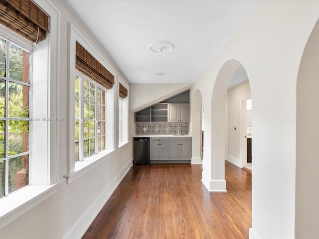 interior space featuring tasteful backsplash, a healthy amount of sunlight, dishwasher, and gray cabinetry