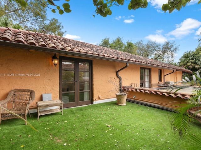 rear view of house featuring a yard and french doors