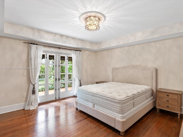 bedroom with dark hardwood / wood-style flooring, access to exterior, and french doors