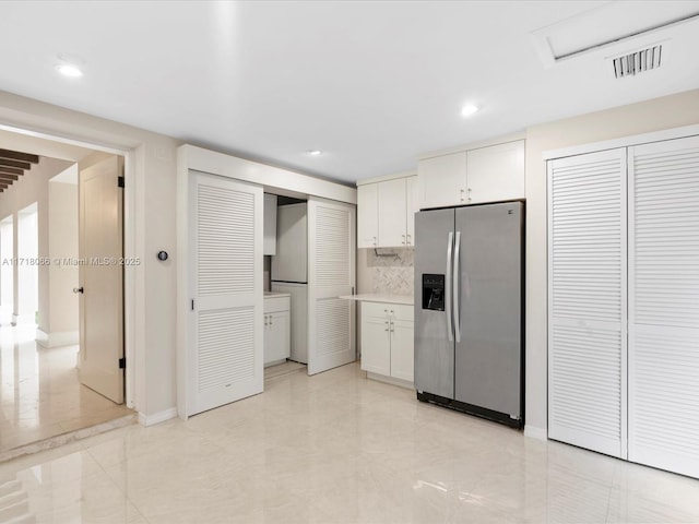 kitchen featuring white cabinetry, stainless steel fridge with ice dispenser, and backsplash