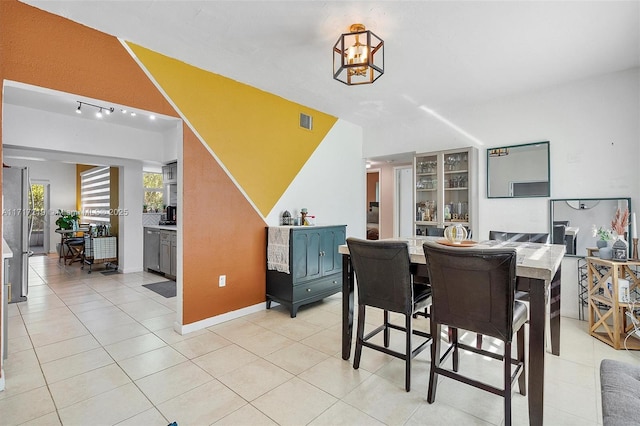 tiled dining space with an inviting chandelier